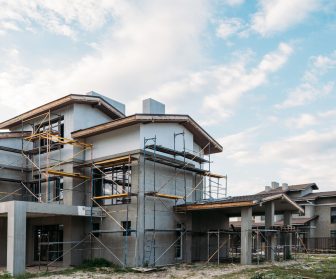 modern building construction with scaffolding under cloudy sky
